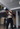 Eine Frau in Sportbekleidung schwingt eine graue Kettlebell auf Brusthöhe während eines funktionellen Trainings